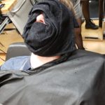 Alex Payne with warm towel on face after shave