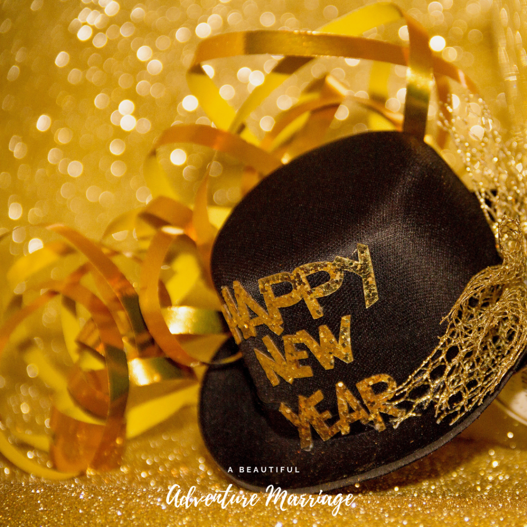 Black Hat with Happy New Year wrote on it surrounded by gold glitter. The blog is about going into the new year with gratitude and goals.
