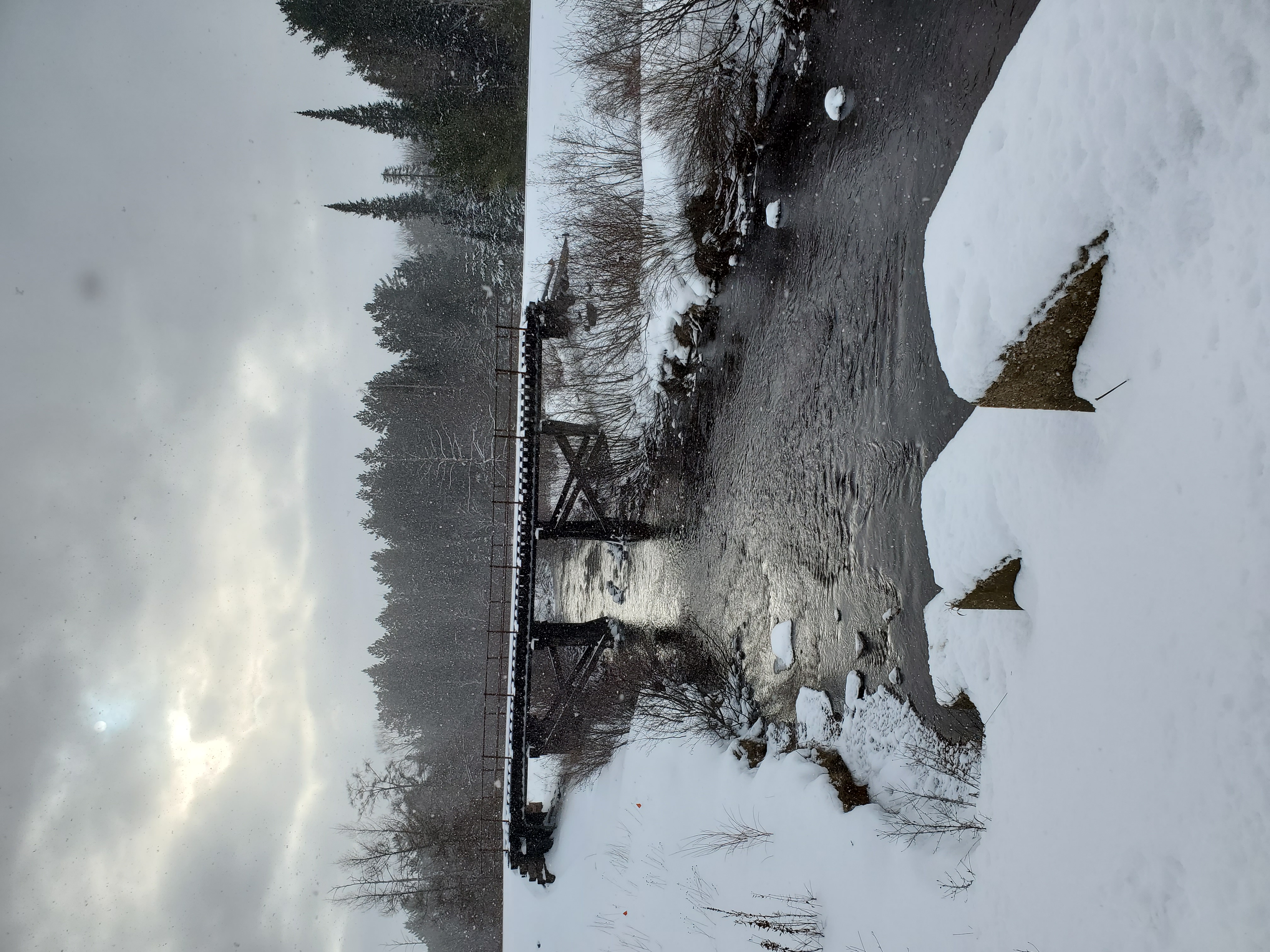 a snow covered bridge over a river in Michigan