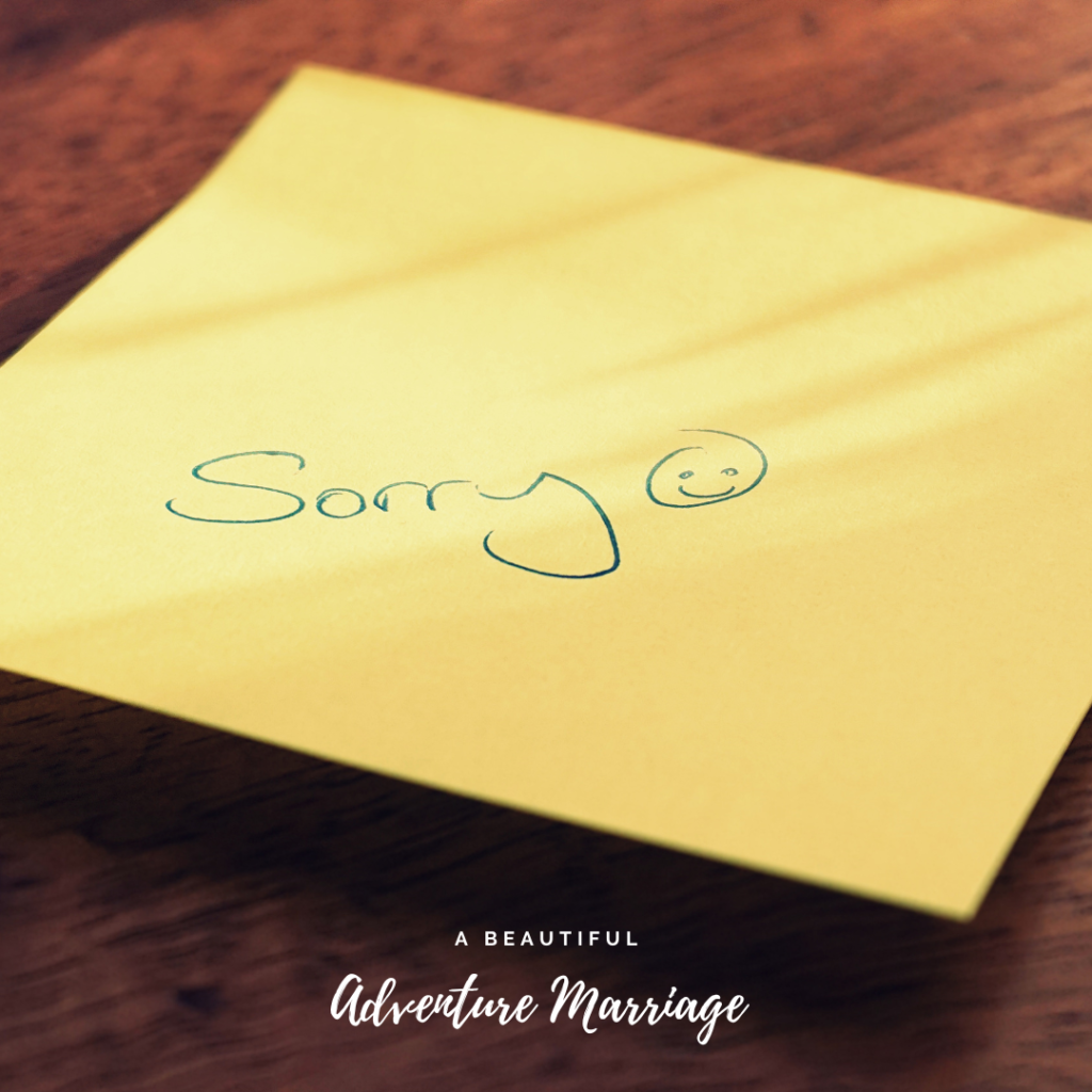 A Yellow Post It Note with the word "Sorry" written on it with a smiley face beside the word